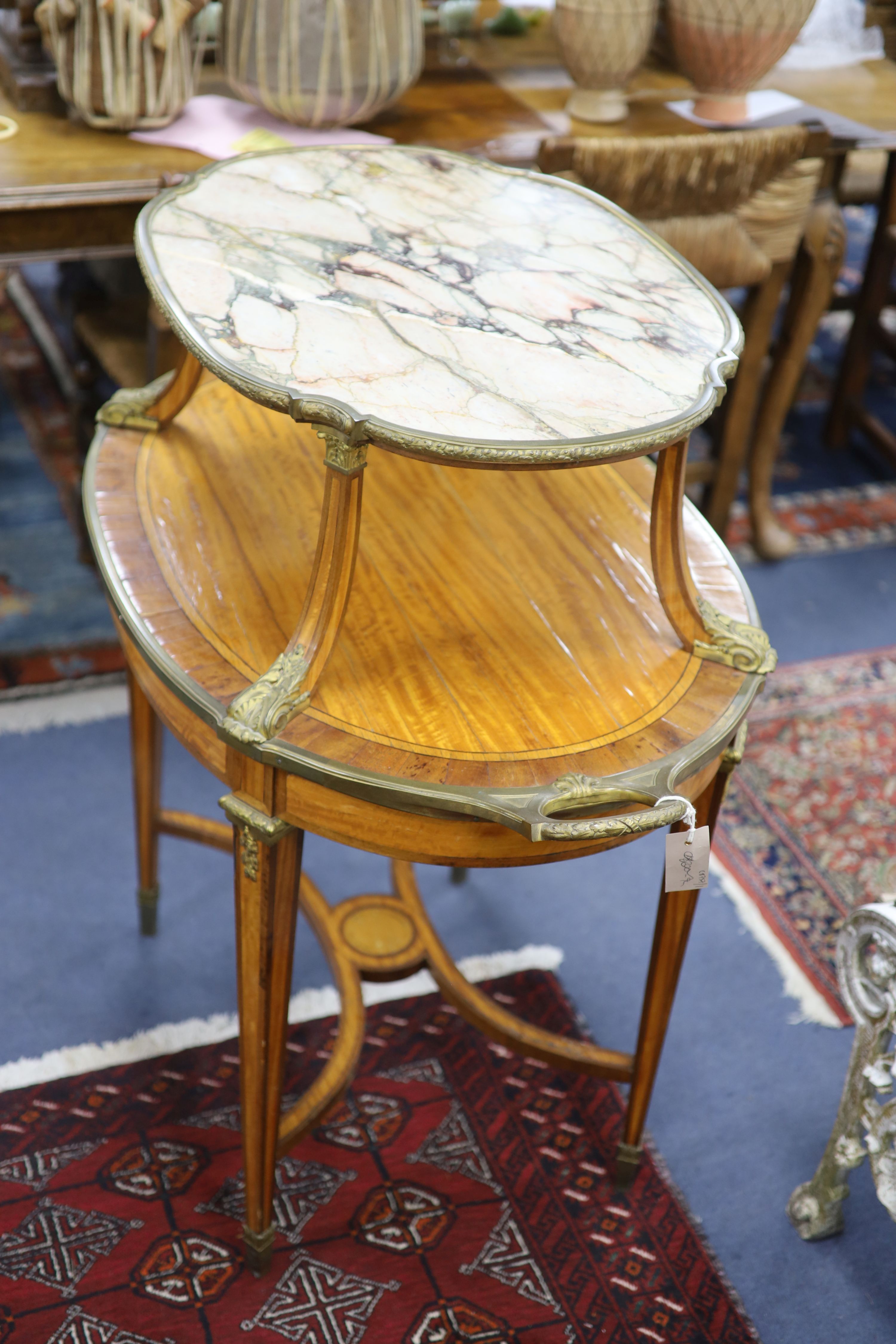 A late 19th century French satinwood, rosewood crossbanded and gilt metal mounted two tier oval etagere,